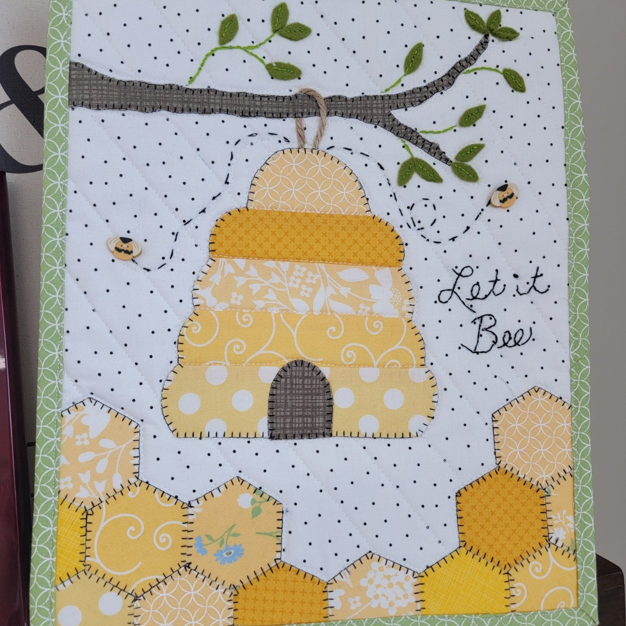 Let it Bee mini quilt featuring a beehive and honeycomb.