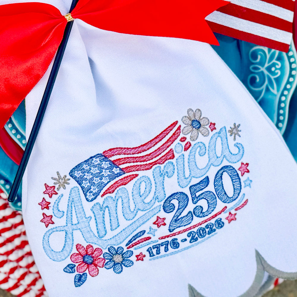 Embroidered apron with 'America 250' design on a decorative background