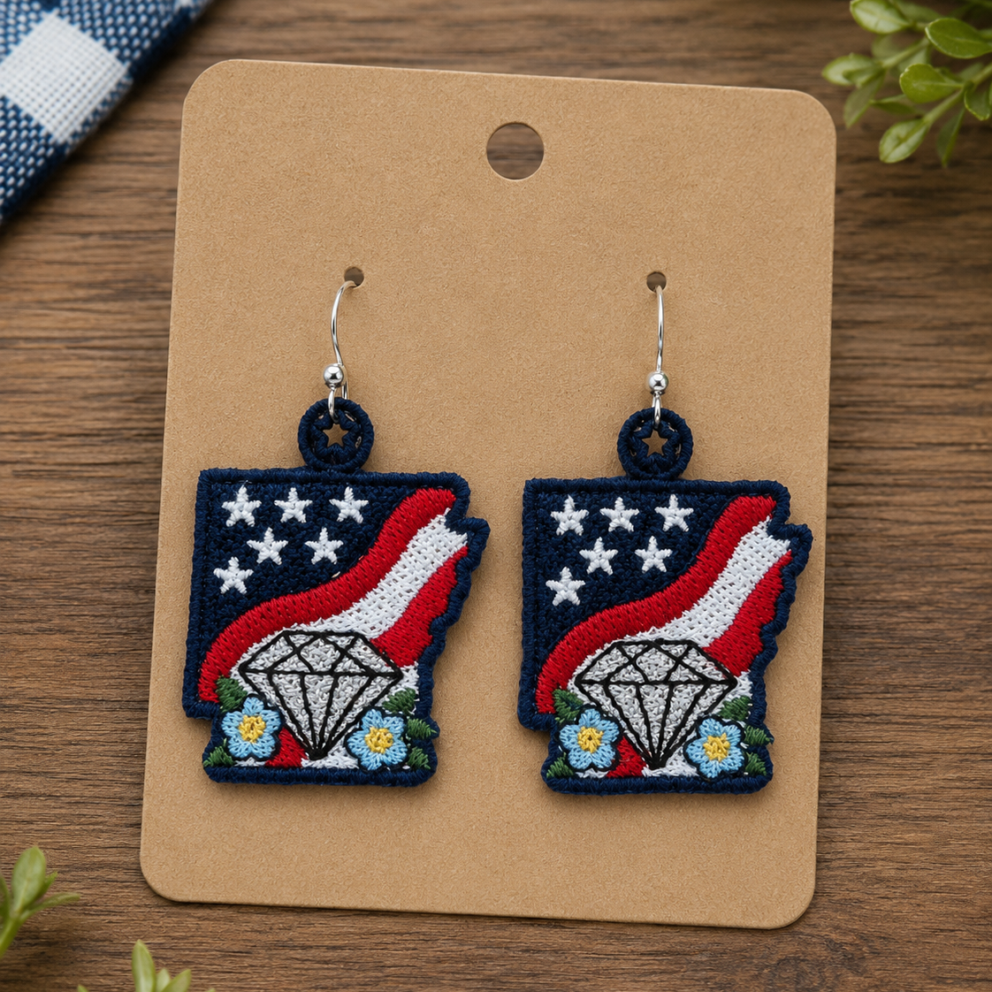 Pair of earrings on a brown card with a wooden background