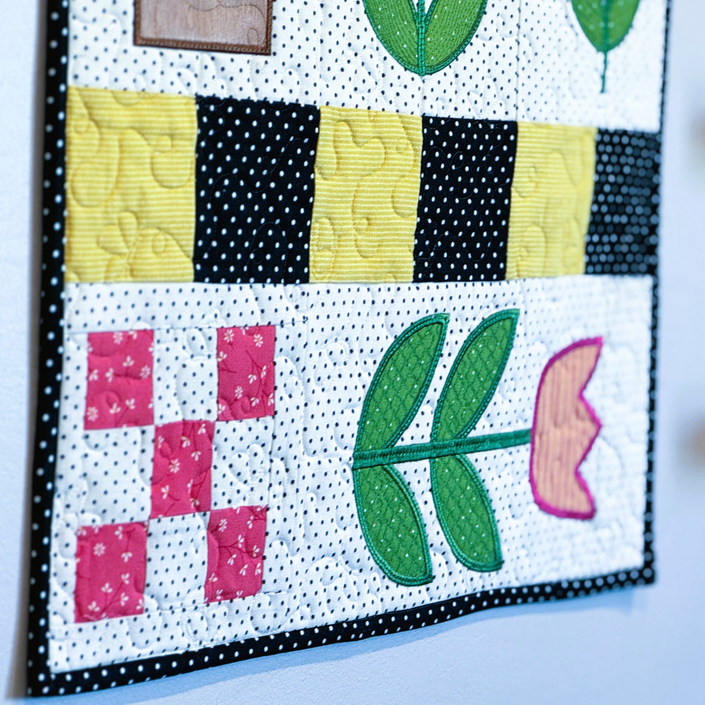 Colorful quilt block with floral patterns on a white background