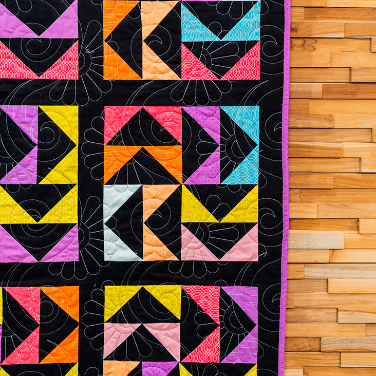 Colorful geometric quilt on a wooden surface