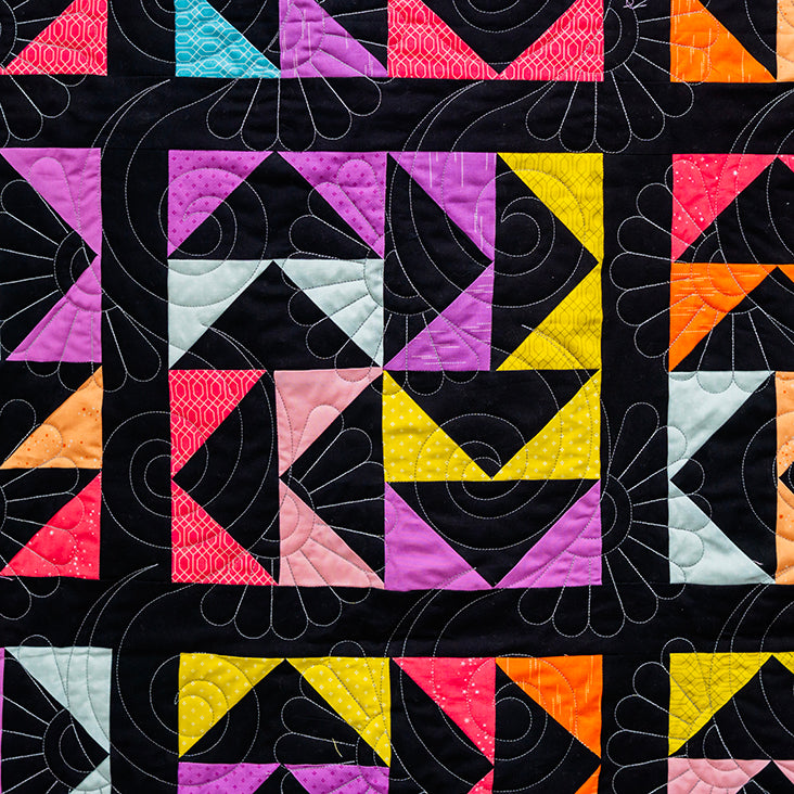 Colorful geometric quilt pattern with triangles on a black background
