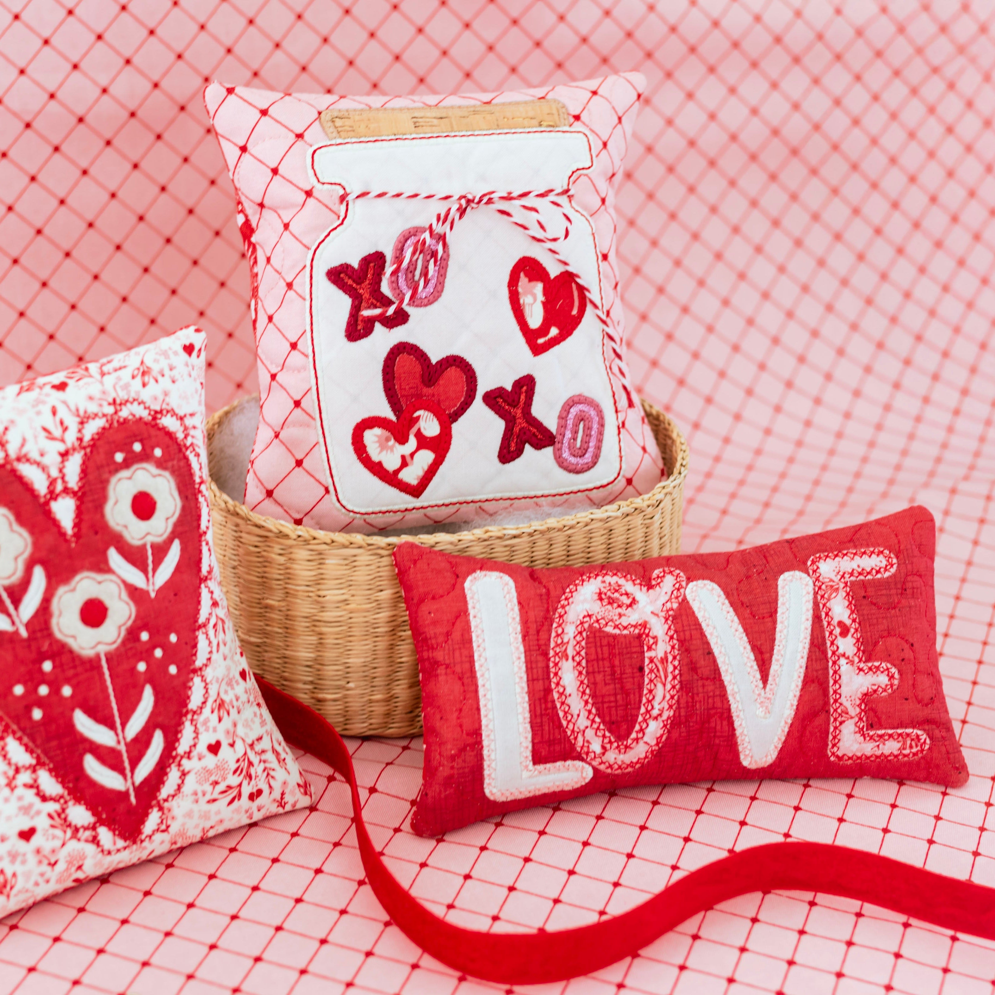 Decorative pillows with heart and 'LOVE' designs on a red checkered background
