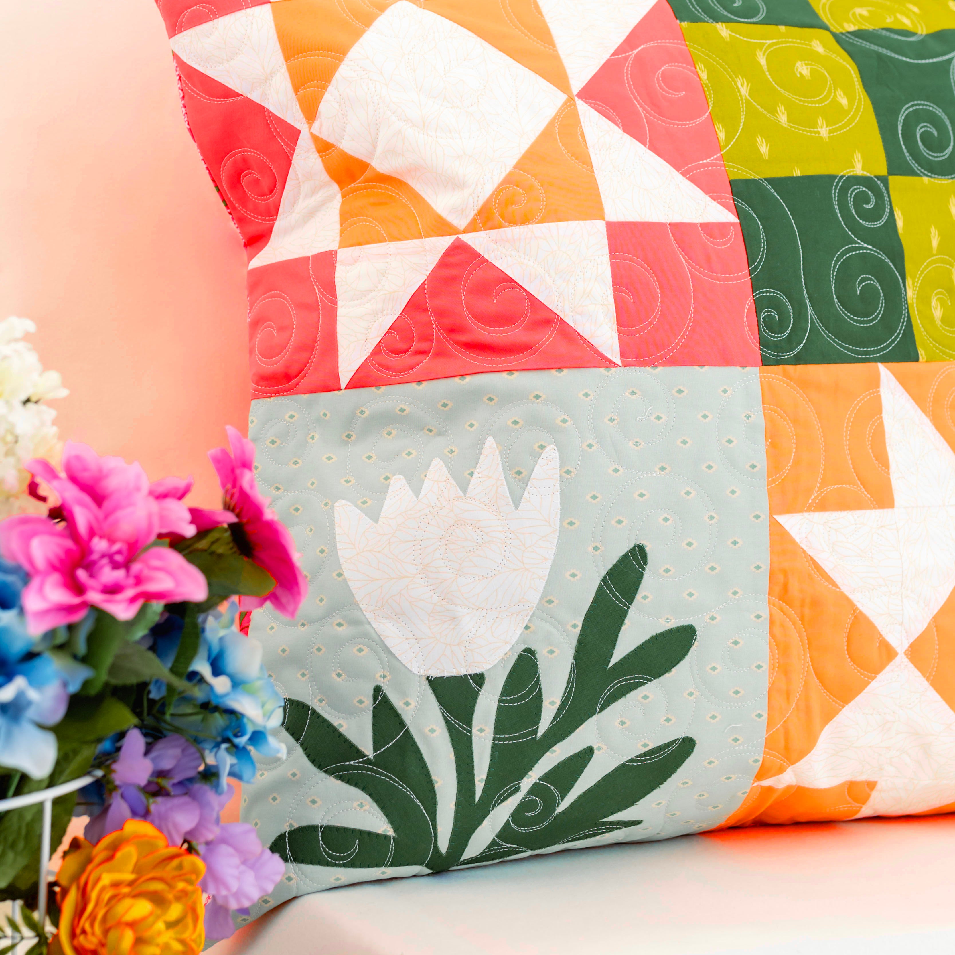 Colorful quilted pillows with floral design on a light background