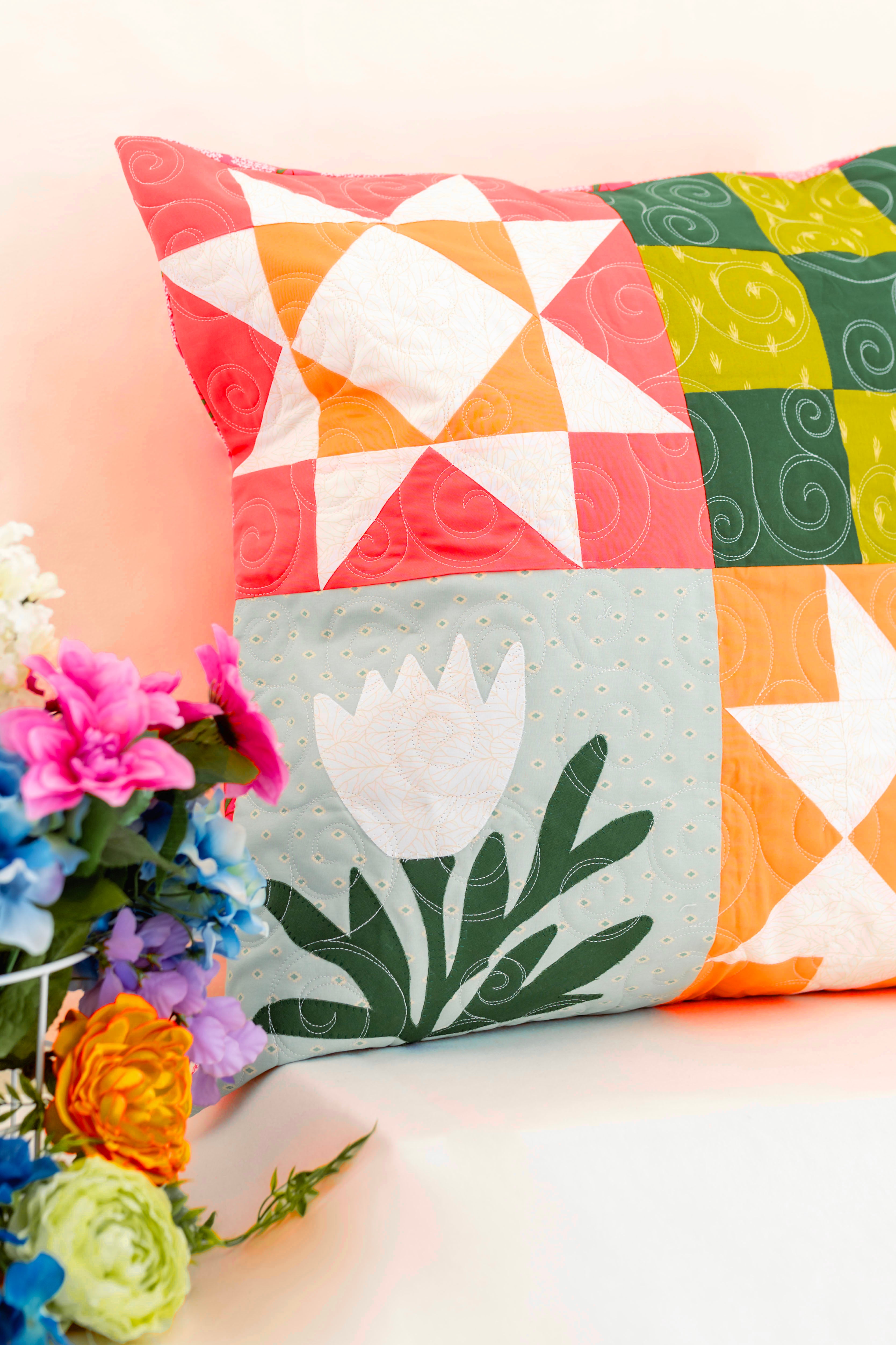 Colorful quilted pillows with floral design on a light background