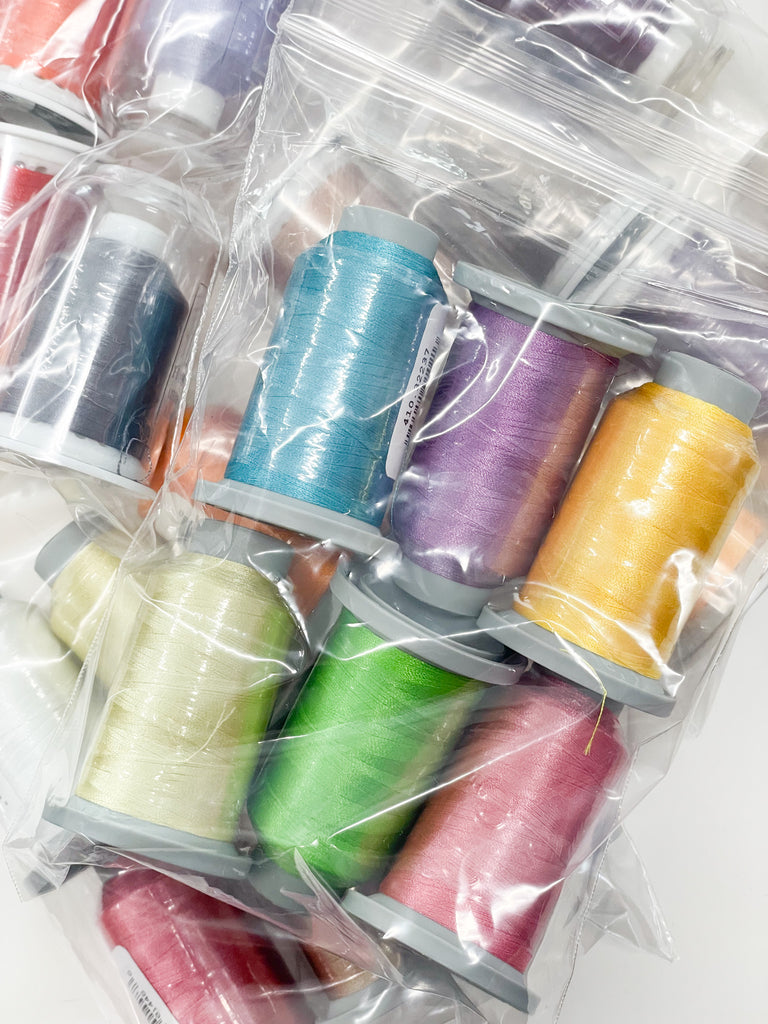 Six colored spools of Glide thread in a plastic bag
