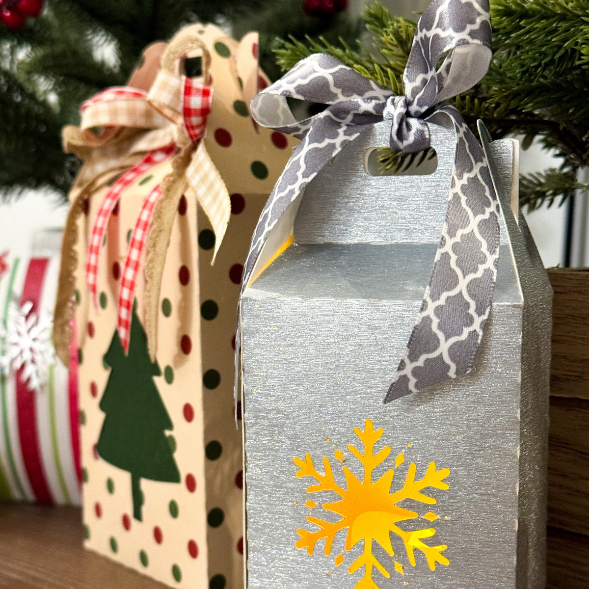 Decorative gift boxes with ribbons and a snowflake design on a wooden surface.