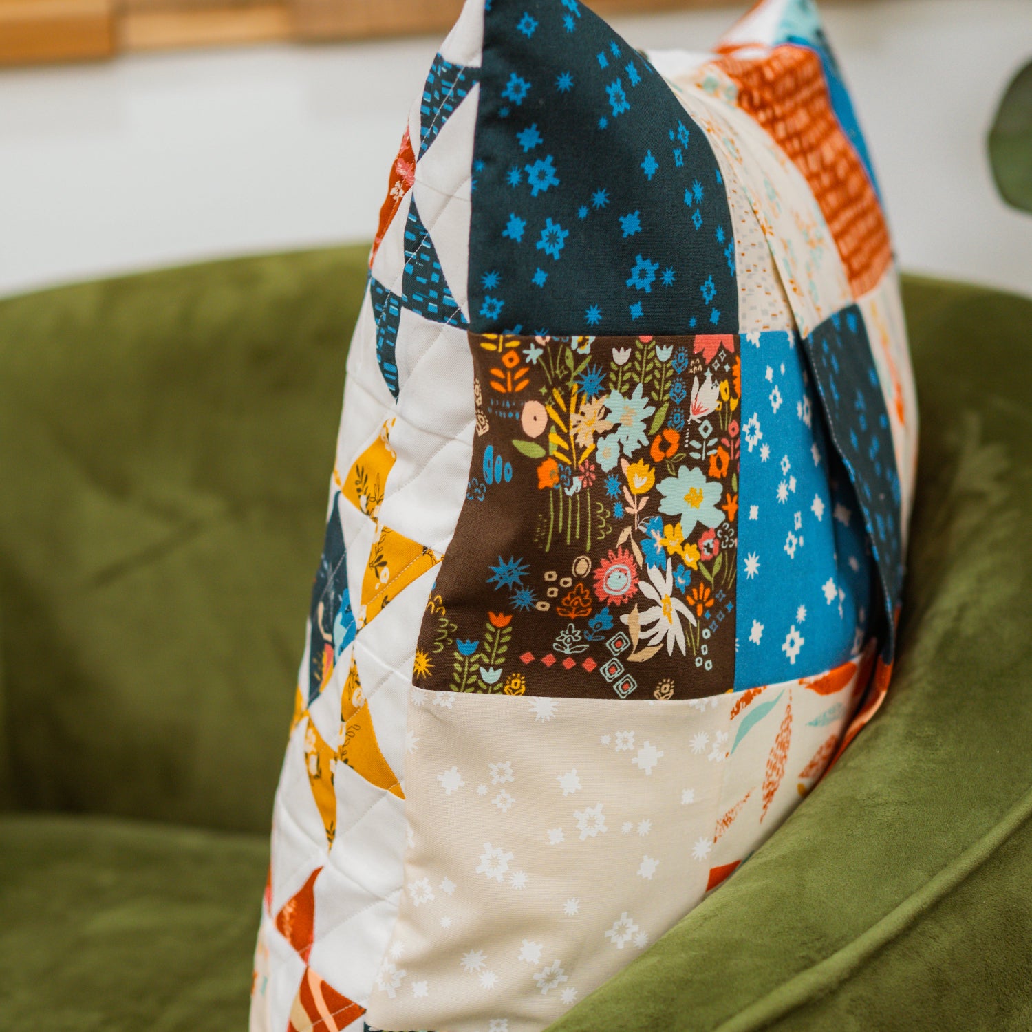 Colorful patchwork quilt draped over a green chair