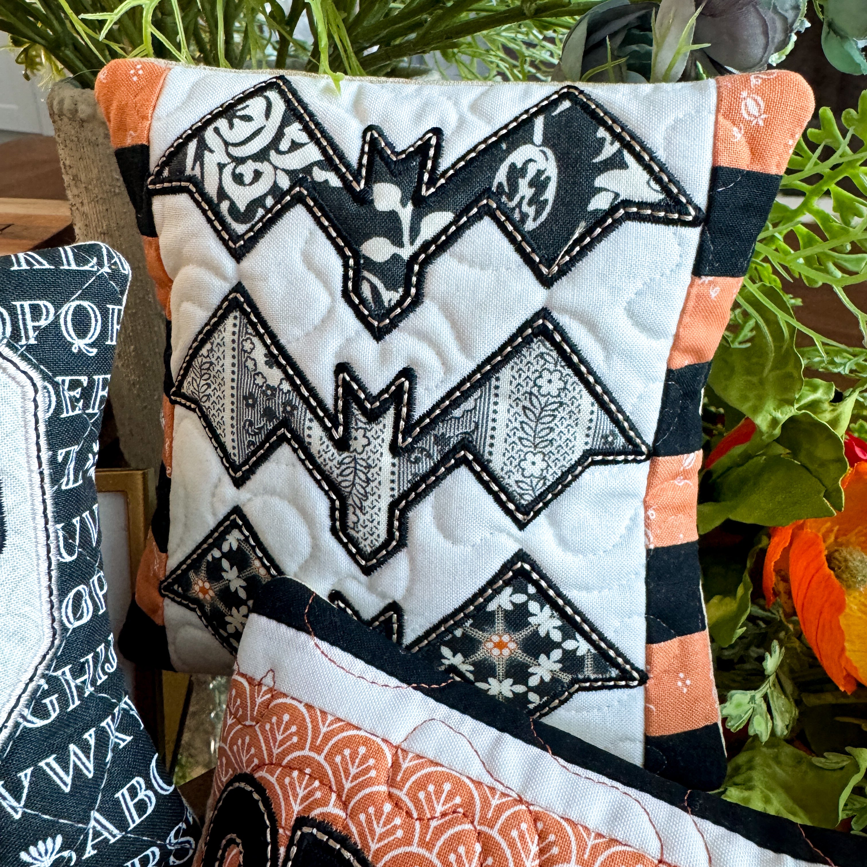 Decorative pillow with bat pattern and Halloween-themed design in a room setting.