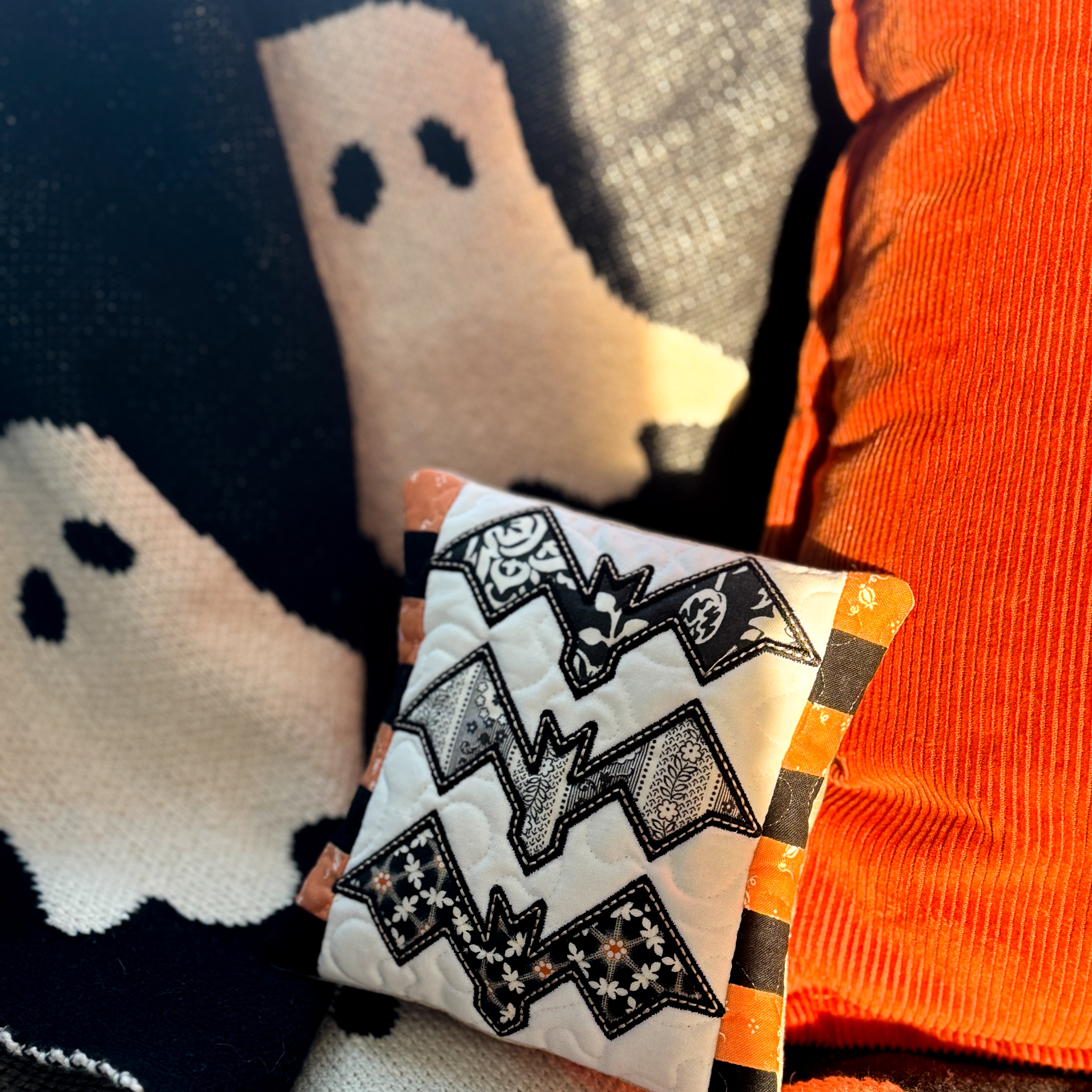 Halloween-themed pillow with ghost design on a soft surface