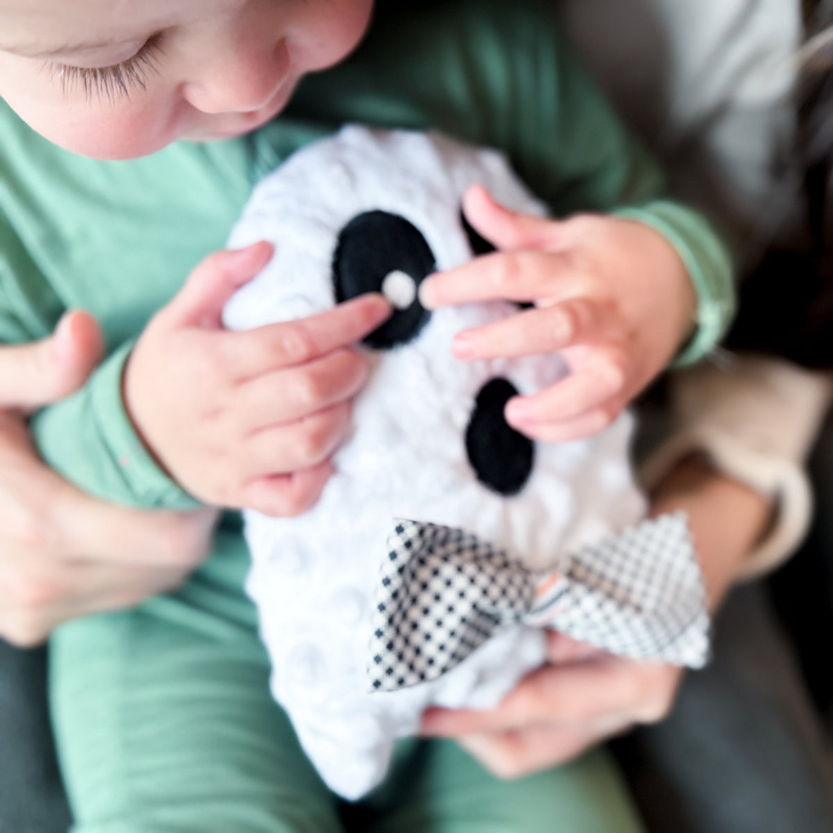 Child playing with a plush ghost toy