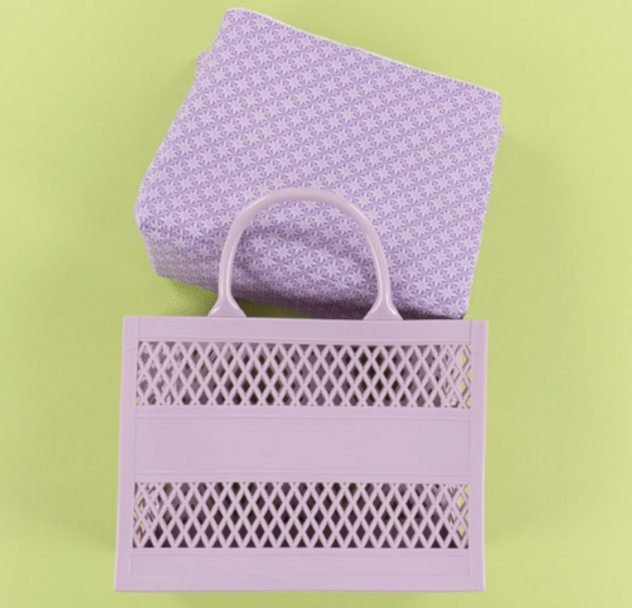 Purple patterned bag and tote on a green background