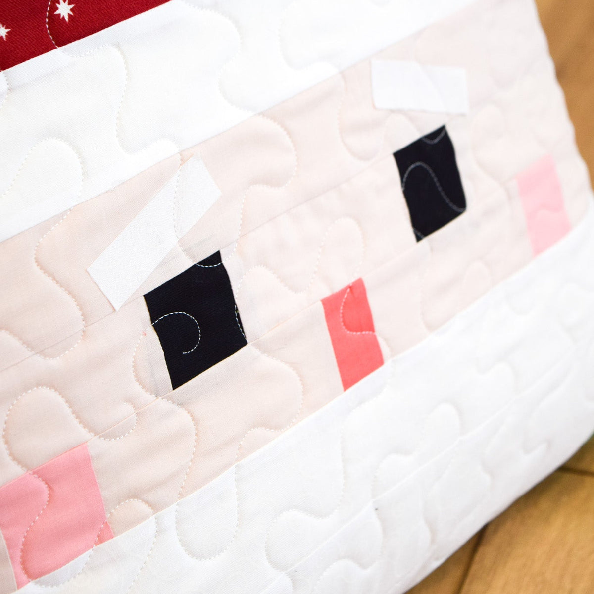 Quilt with a cartoonish face design on a wooden surface