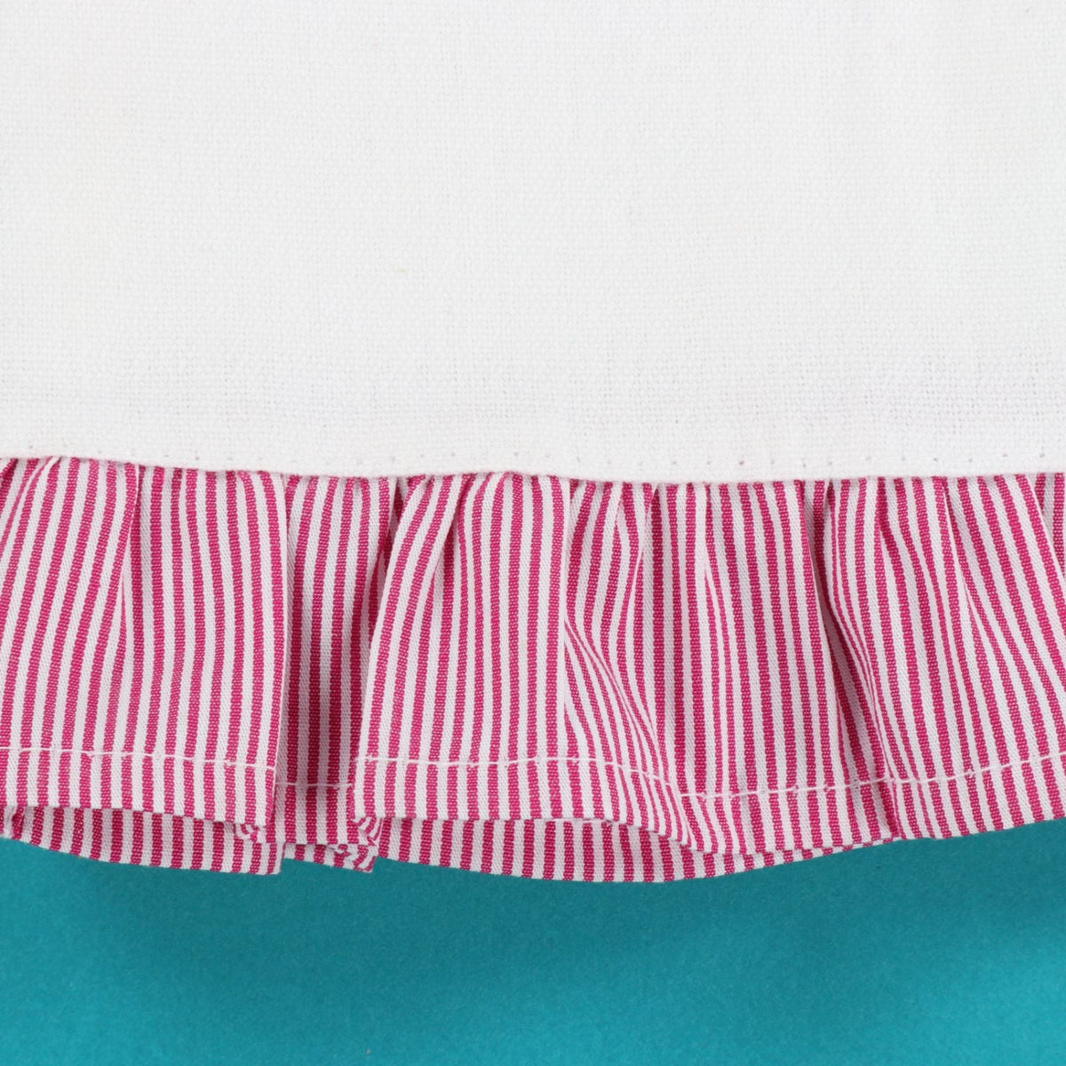 Red and white striped fabric with a ruffled edge on a teal background