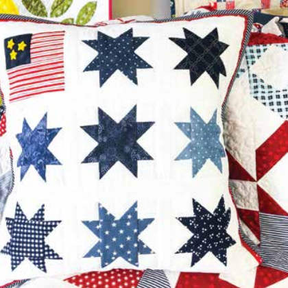 A square pillow with star-shaped quilt blocks.