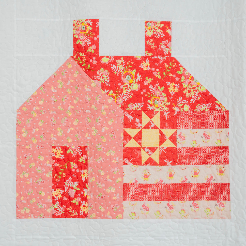 Patchwork quilt block with floral and geometric patterns on a white background