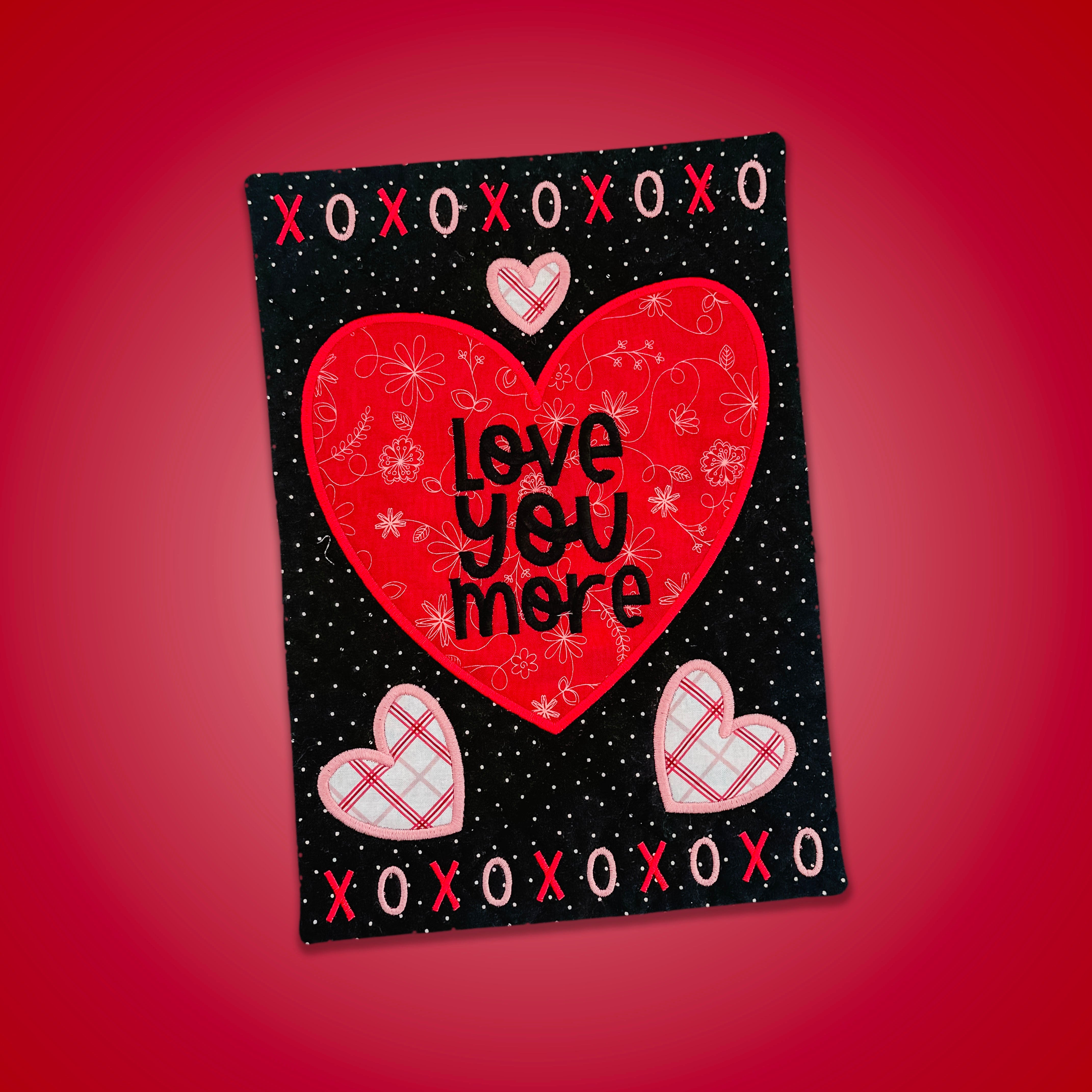 Card with red heart and 'Love You More' text on a red background