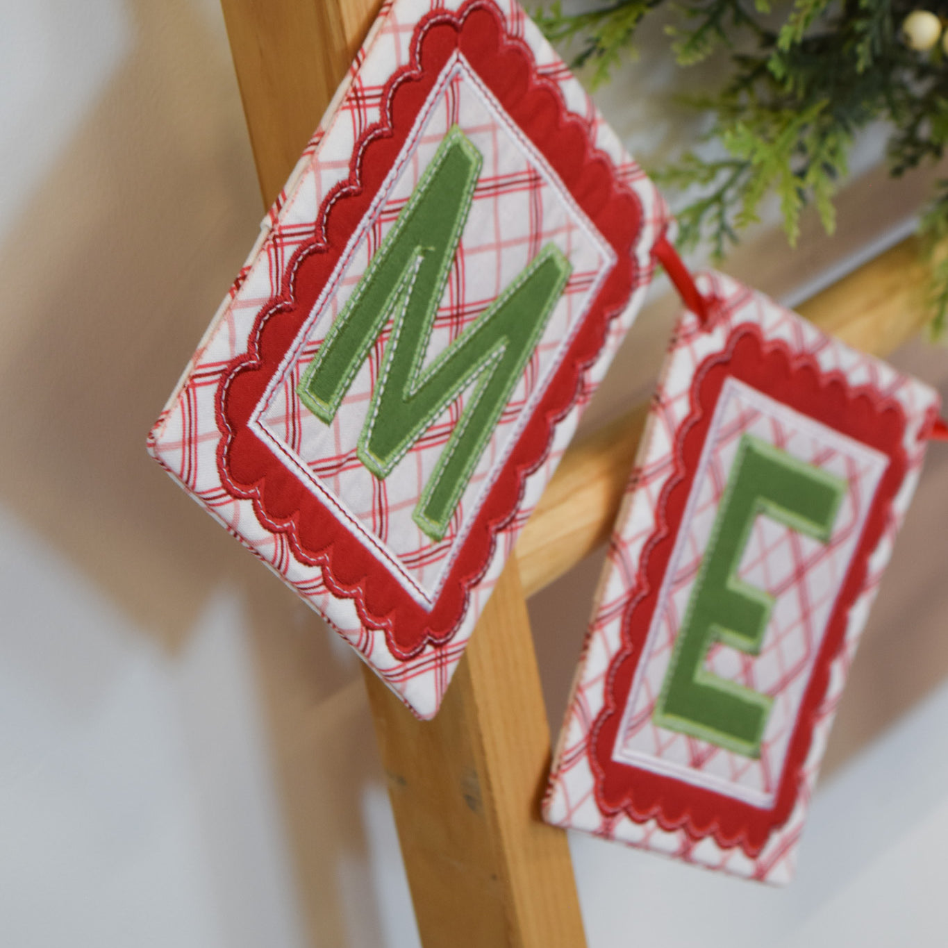 Decorative Christmas banner with 'M E' letters on a wooden stand.