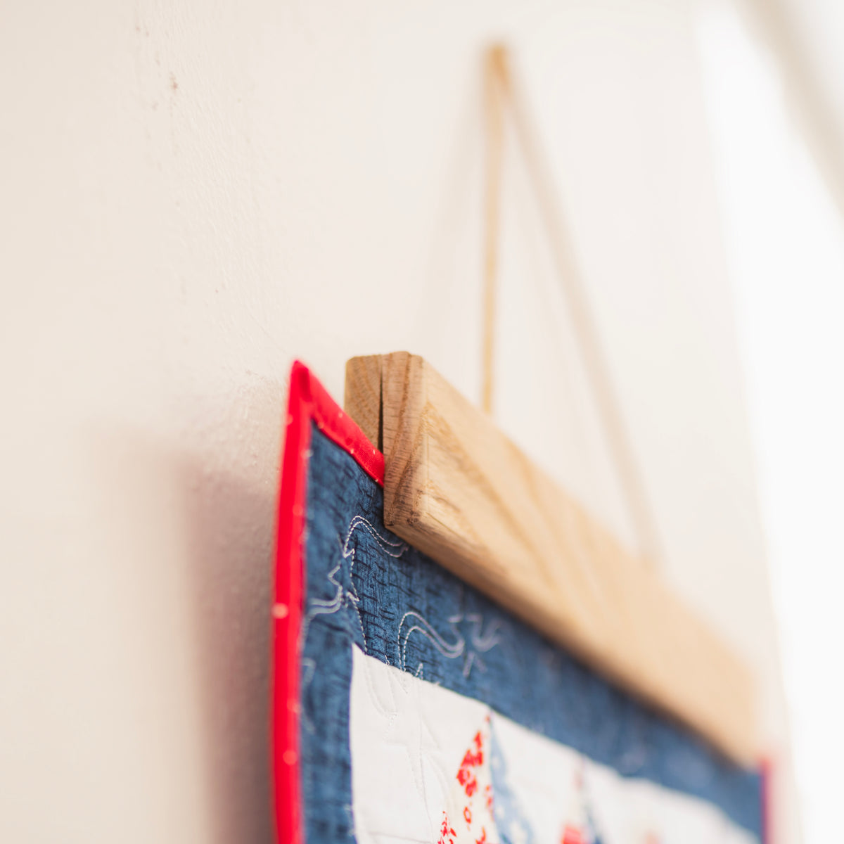 Close-up of a wooden picture frame with a red border on a light background 18" wall hanger
