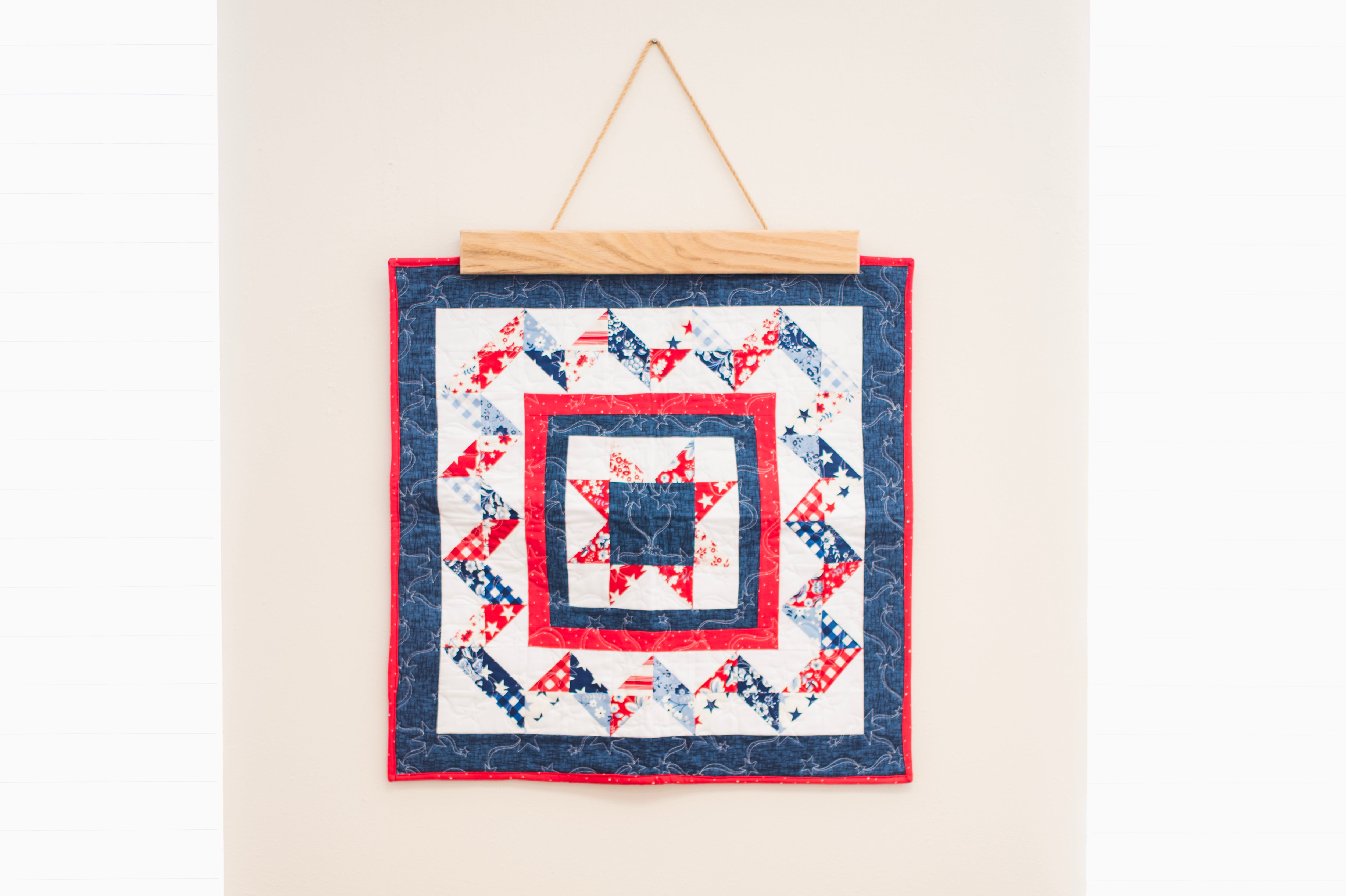 Quilt with red, white, and blue pattern hanging on a wall 18" wall hanger