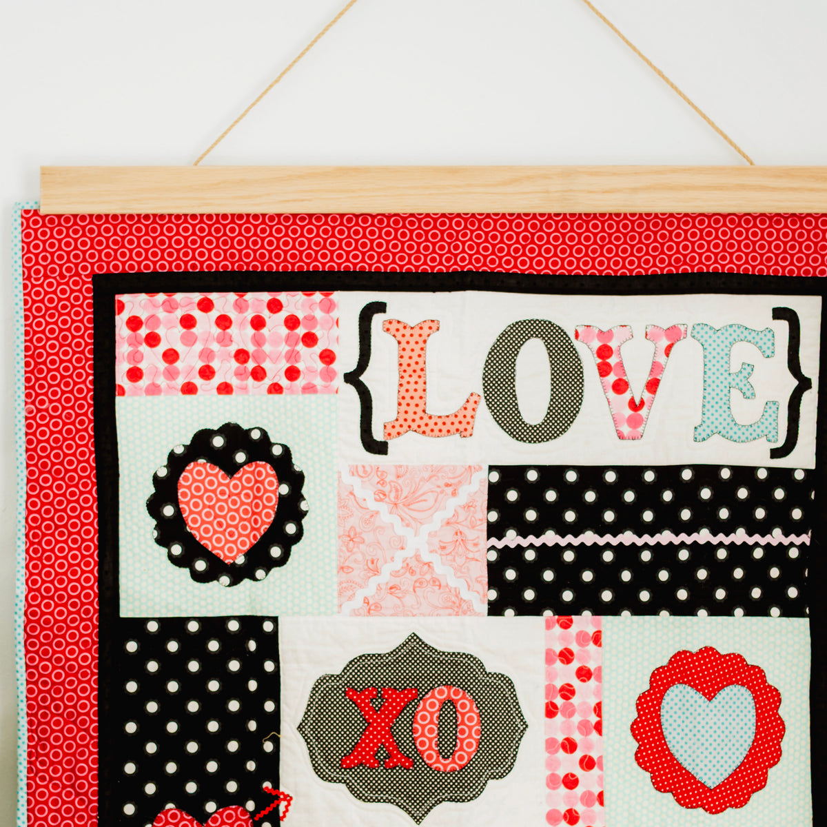 Decorative wall hanging with 'LOVE' and heart designs on a red background. 36" wall hanger