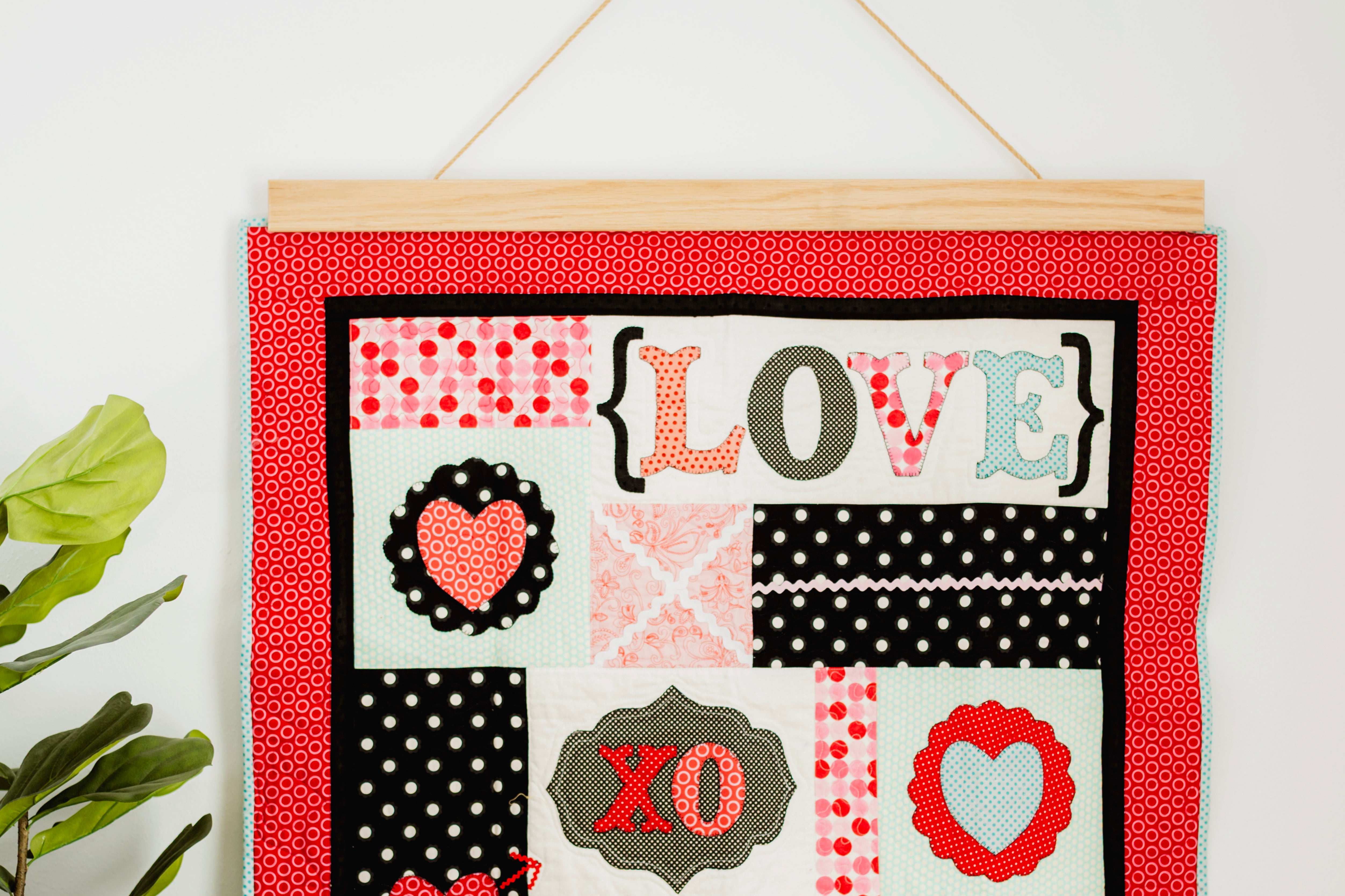 Decorative wall hanging with 'LOVE' and heart designs on a red background. 36" wall hanger