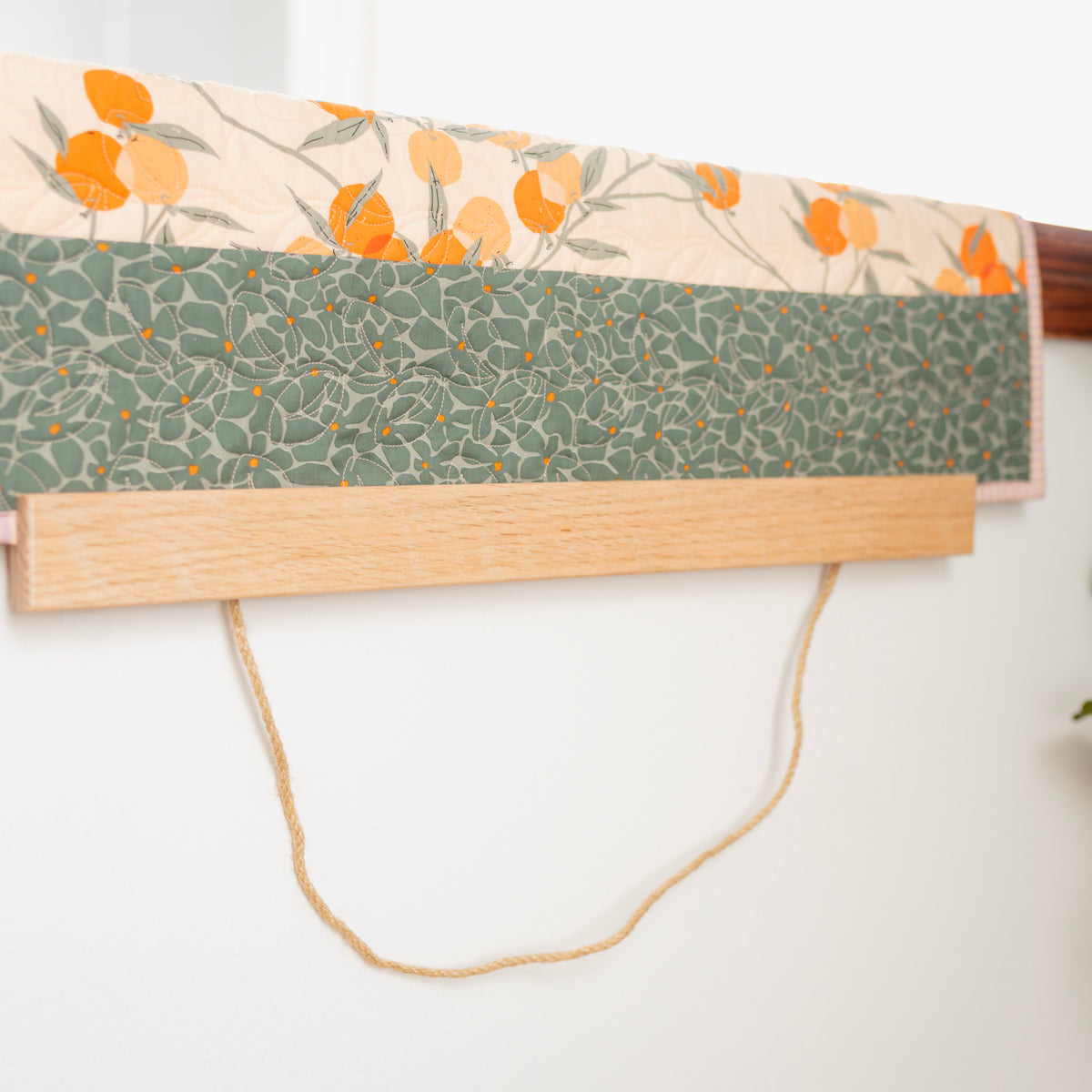 Fabric with floral and geometric patterns on a wooden board with a white background 24" wall hanger