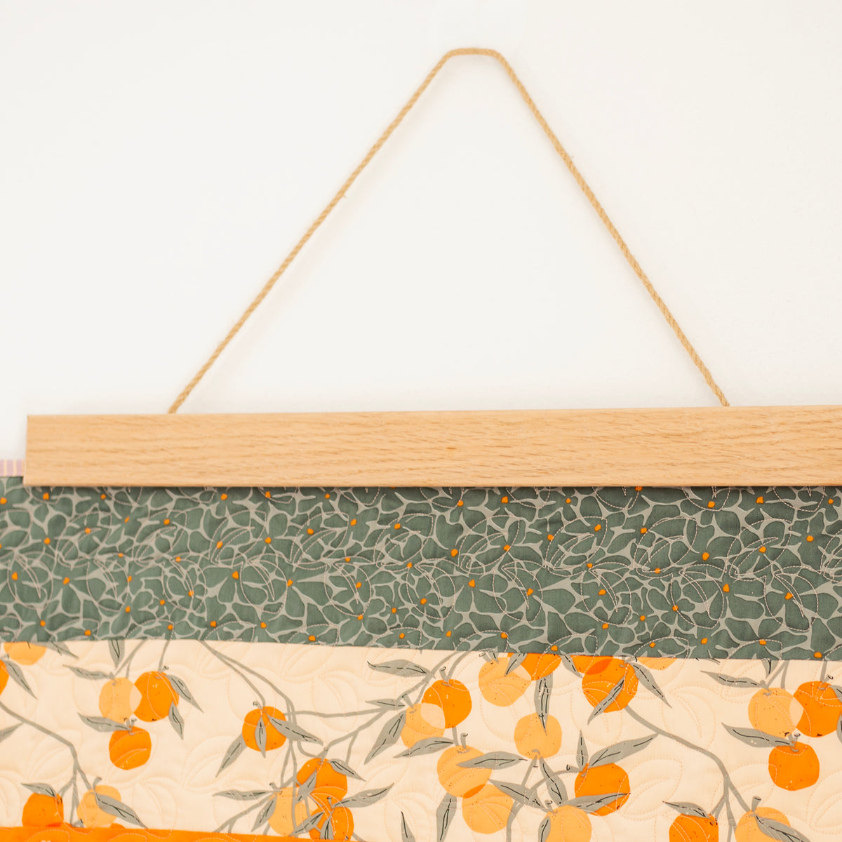 Fabric panel with floral pattern hanging on a white background 24" wall hanger