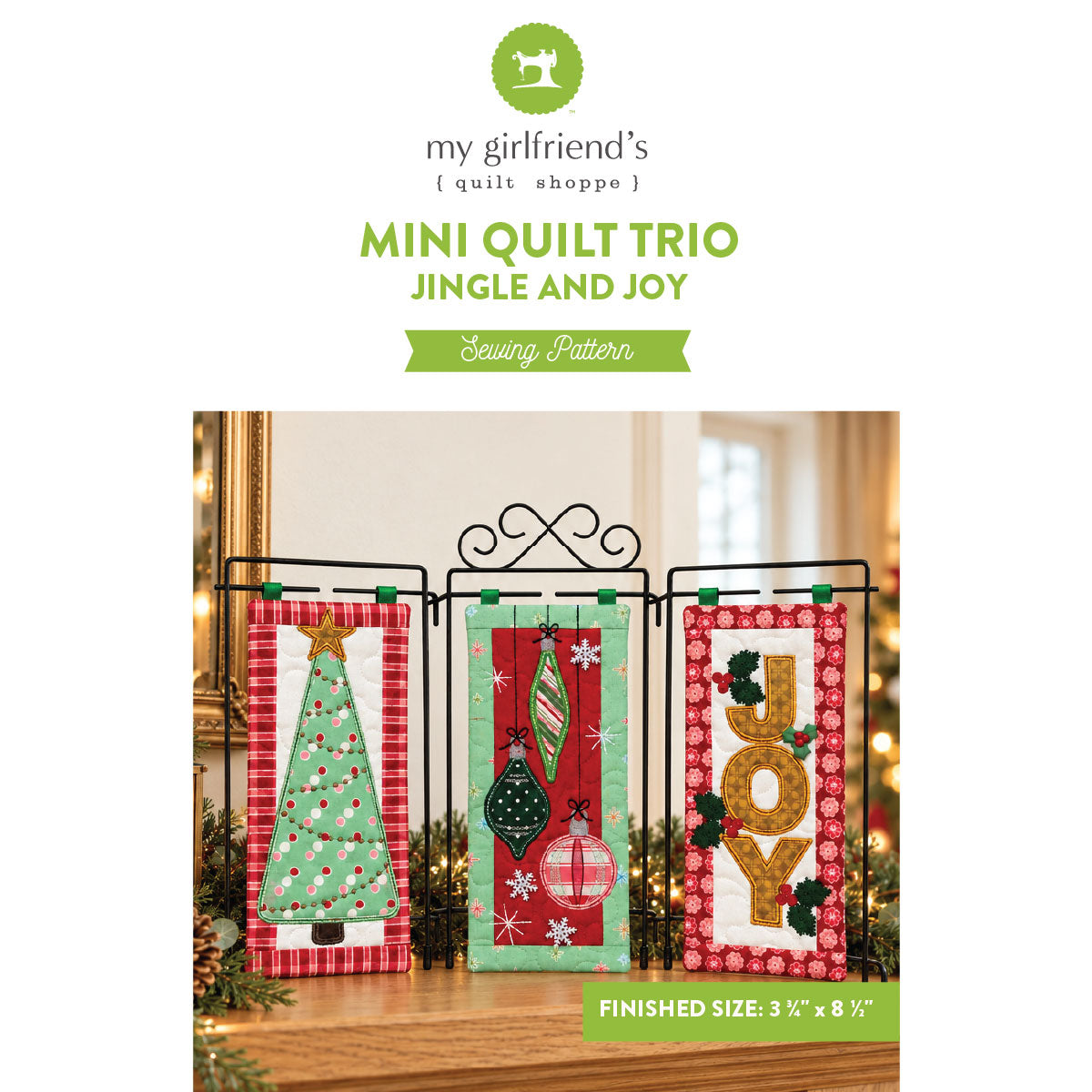 Sewing pattern cover for 'Mini Quilt Trio Jingle and Joy' by my girlfriend's quilt shoppe, showing three festive quilted mini flags displayed on a black metal stand in a warmly lit holiday setting.