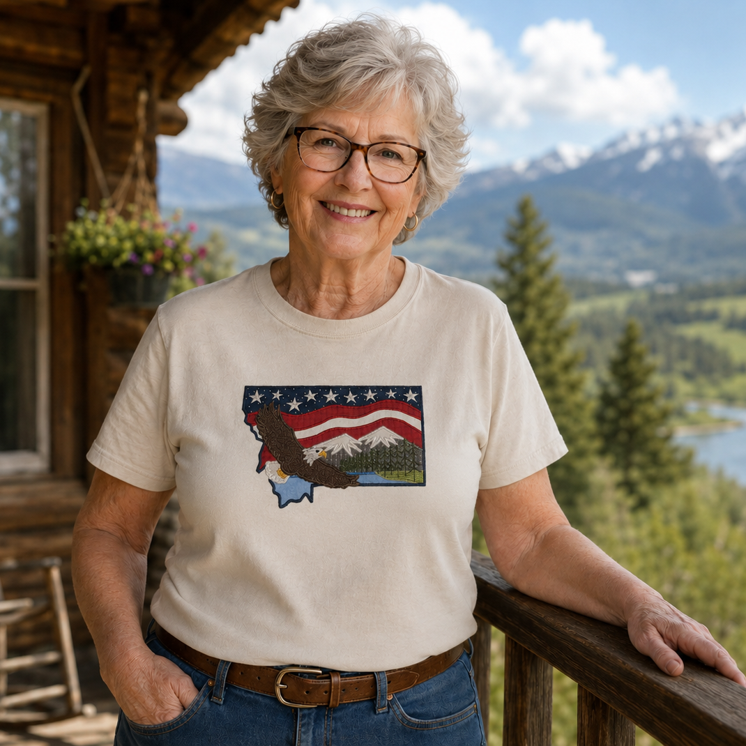 Woman wearing a t-shirt with a graphic design, standing on a deck with a scenic mountain view.