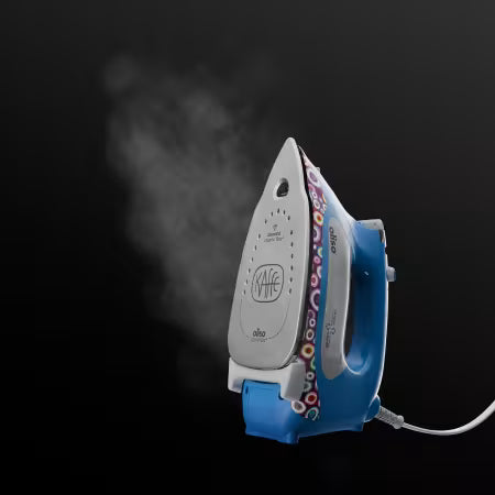 A blue and silver Alva Kiffe steam iron with a colorful patterned edge, shown emitting steam against a dark black background.