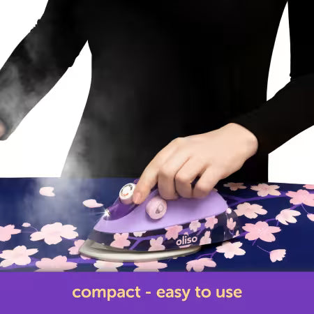 Person using a purple iron on a floral ironing board with 'oliso' branding.