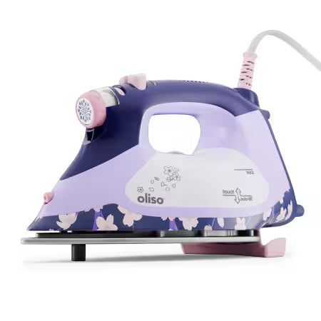 An Oliso steam iron with a purple and lavender color scheme, featuring a floral pattern on the base, a white handle grip, and pink accents on the steam button and cord.