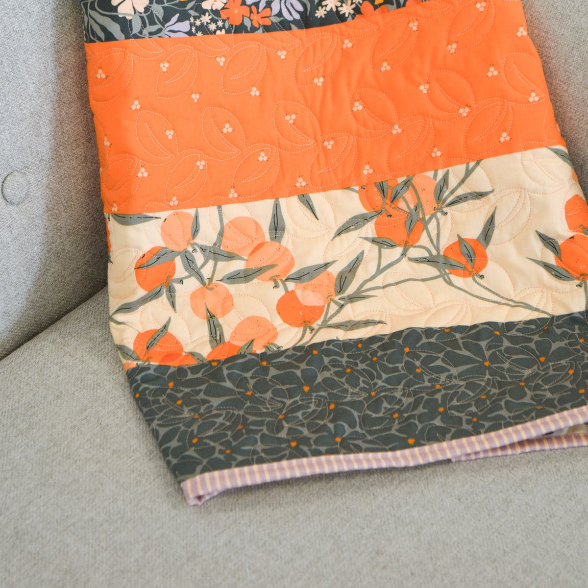 Patchwork quilt with floral and geometric patterns on a chair.