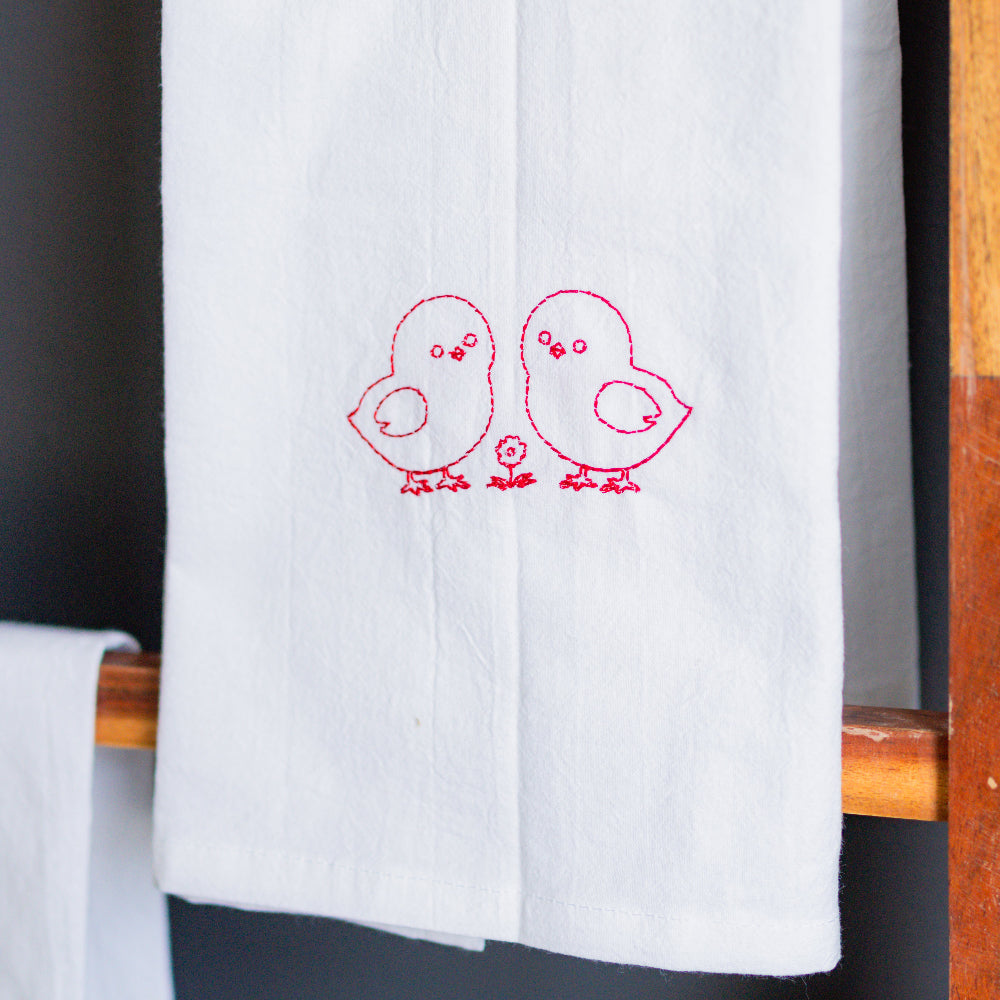 White towel hanging on a wooden rack against a dark background