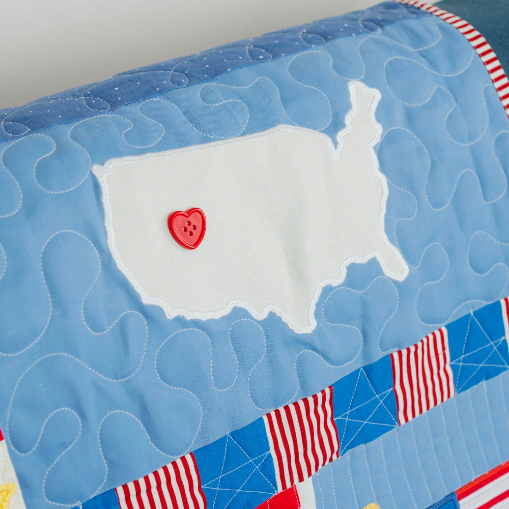 Quilt with USA map, heart, and flags on a blue background