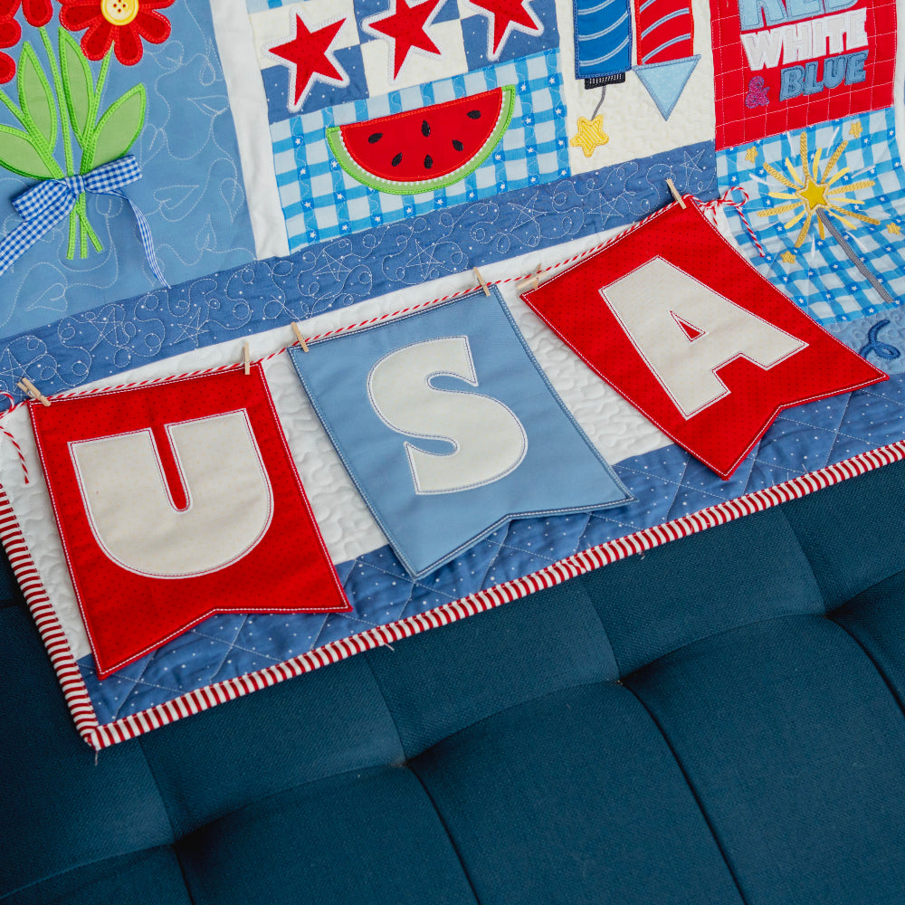 Decorative quilt with 'USA' banner and patriotic elements on a blue couch.