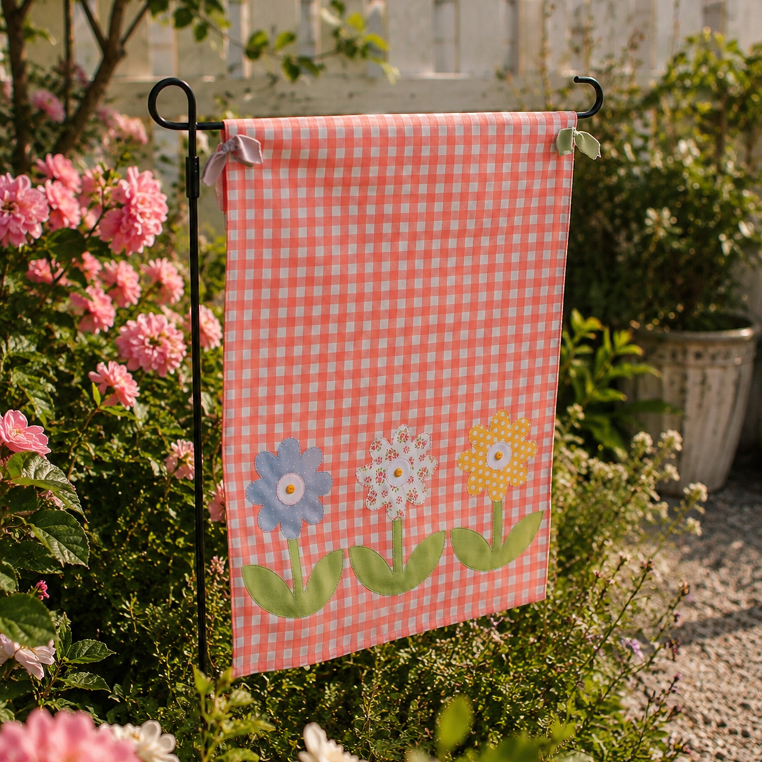 Garden flag with floral design on a stand among flowers and plants