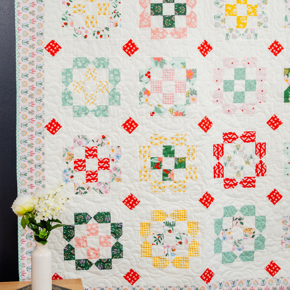 Quilt with colorful square patterns on a white background