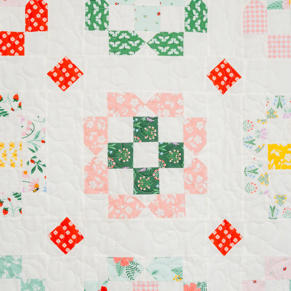 Quilt with colorful square pattern on a white background