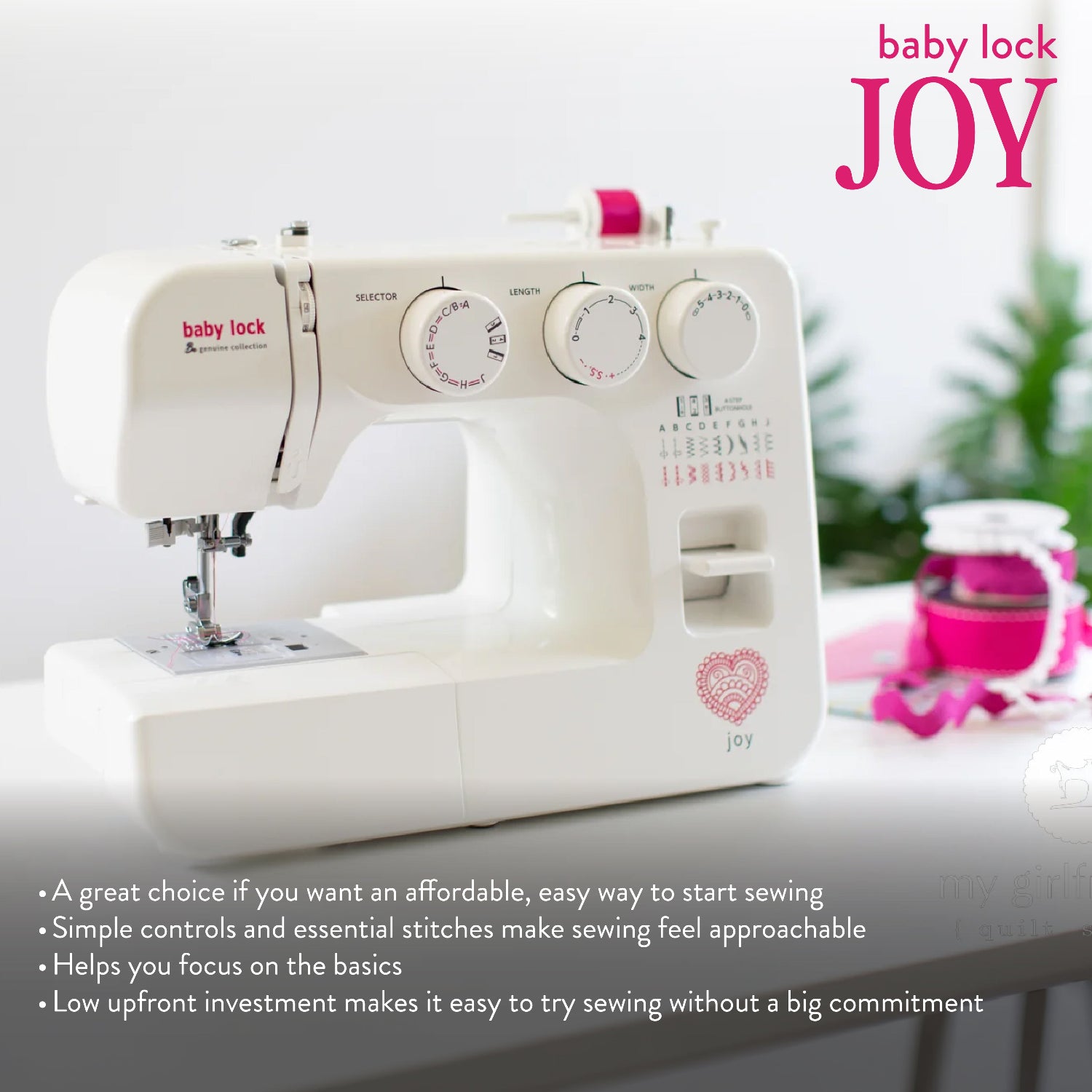A white Baby Lock Joy sewing machine shown on a light tabletop with promotional text and a blurred pink accessory in the background. The product is the sewing machine, and the visible brand is Baby Lock.