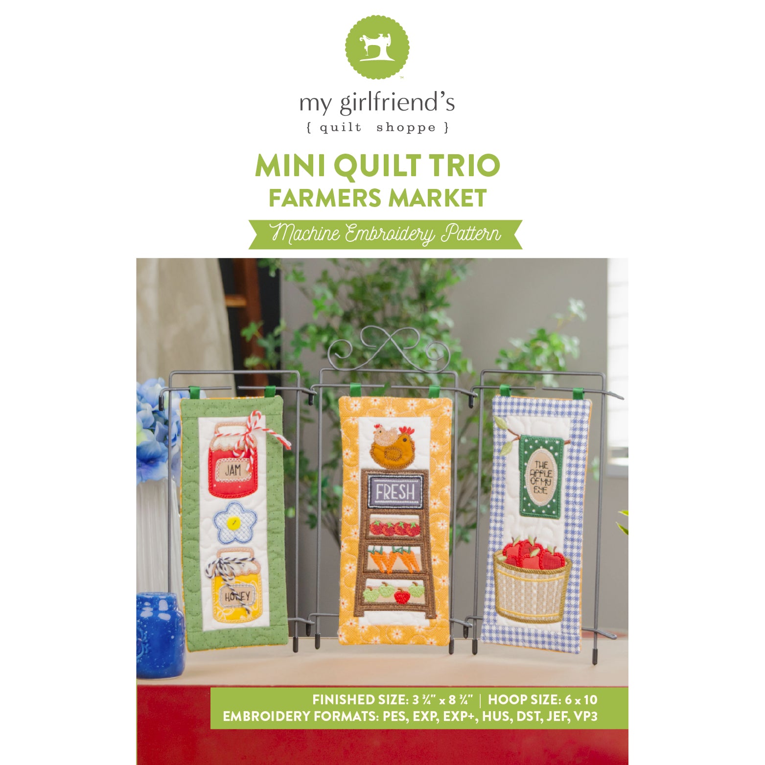 Promotional graphic for 'Mini Quilt Trio Farmers Market' machine embroidery patterns by my girlfriend's quilt shoppe, showing three finished mini quilts hanging on metal stands with a green banner at the bottom detailing embroidery formats and finished size.