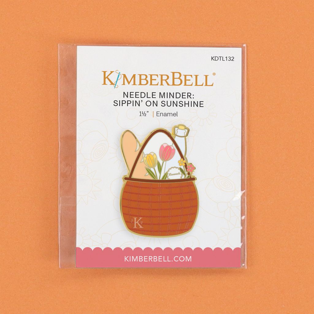 Kimberbell Needle Minder with basket design on a white card against an orange background