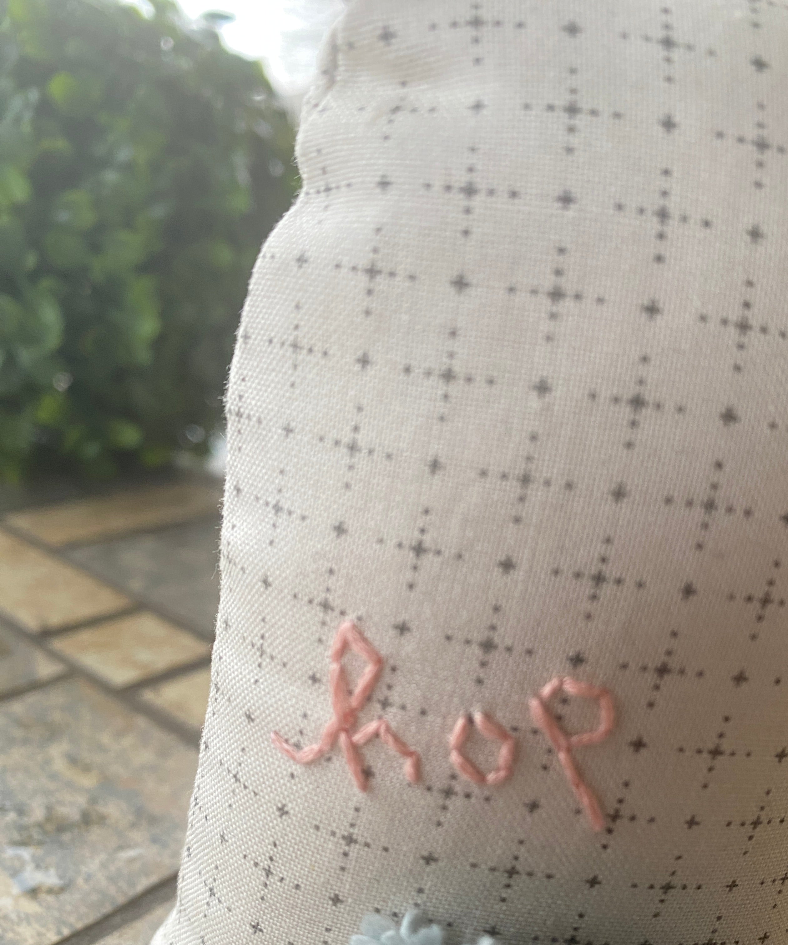 "Hop" hand-embroidered on the back of a bunny pincushion.