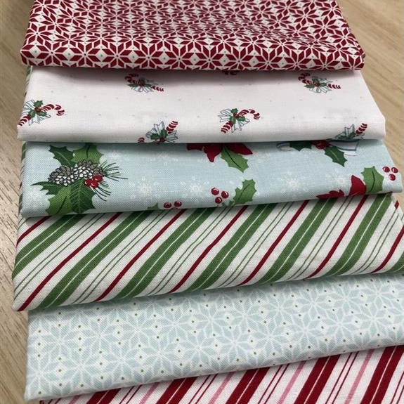 Collection of Christmas-themed fabric swatches on a wooden surface