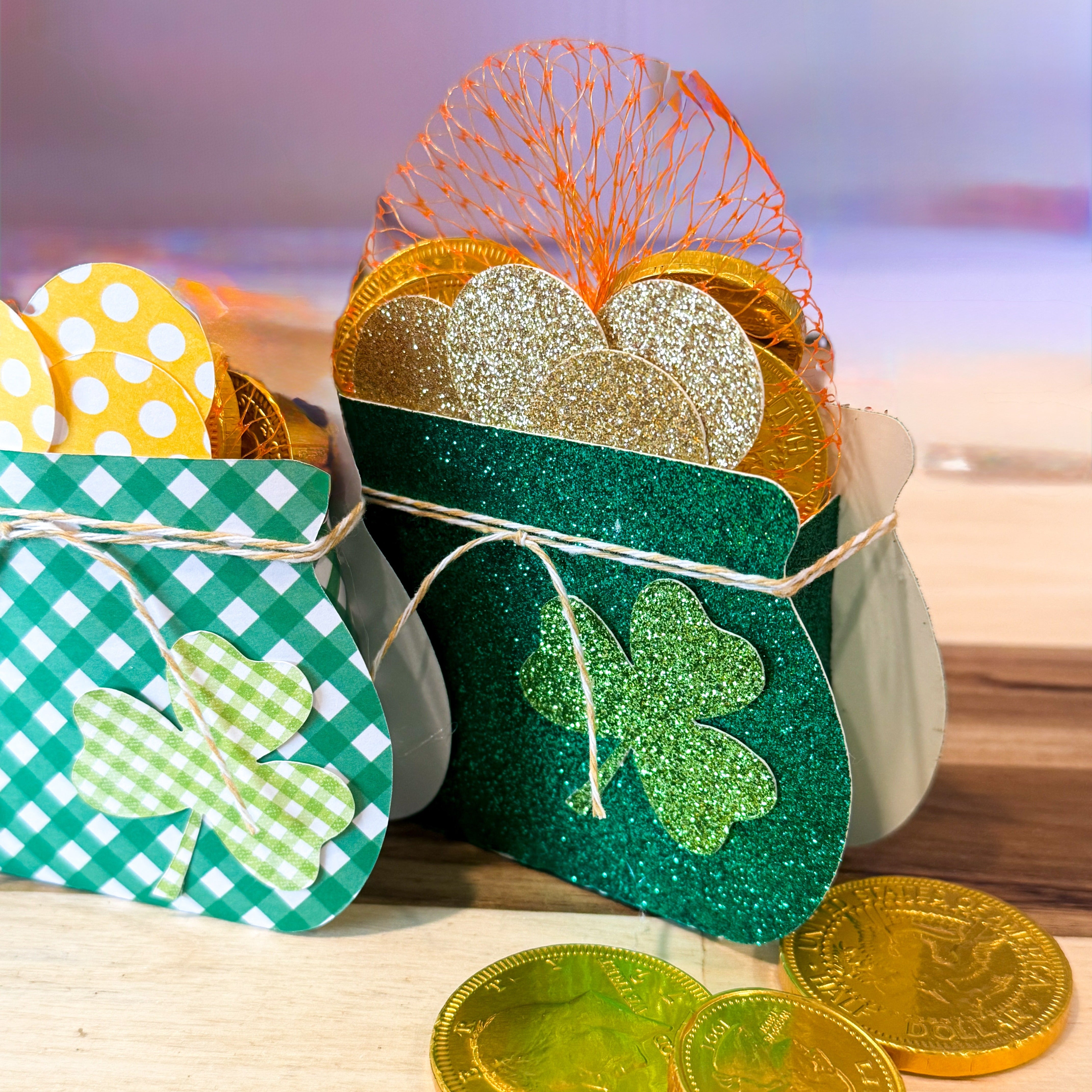 Decorative boxes with shamrock designs and gold coins on a wooden surface