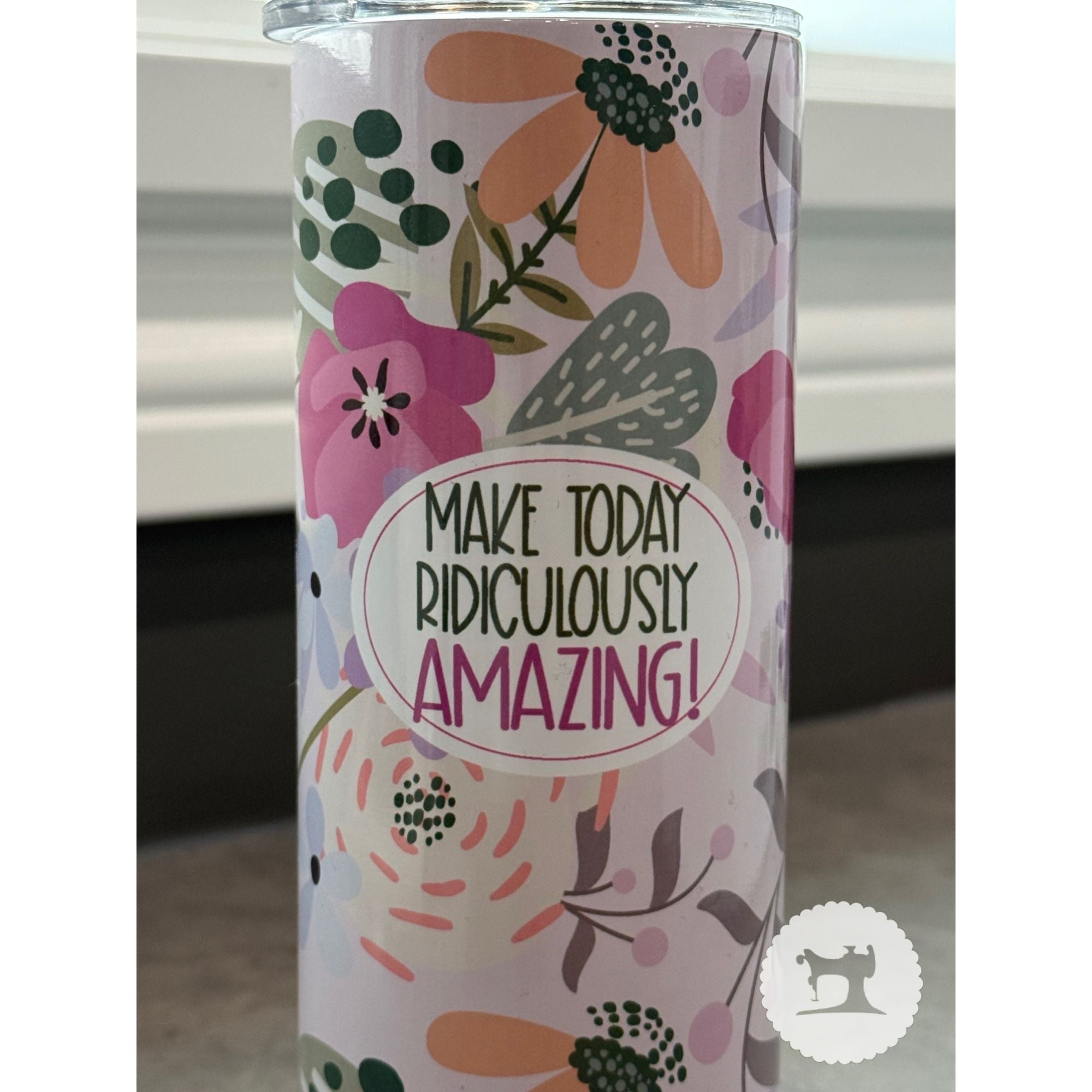 Tumbler with floral design and motivational quote on a white background