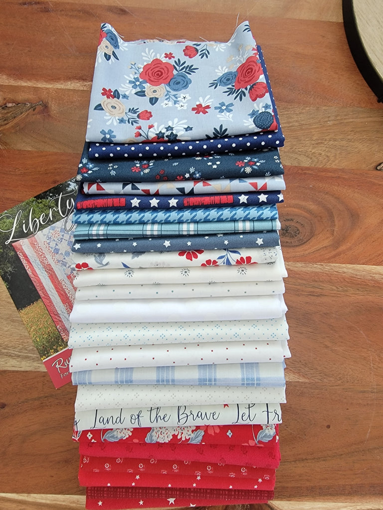Multiple cuts of red, white, and blue fabric in a quilt kit. 