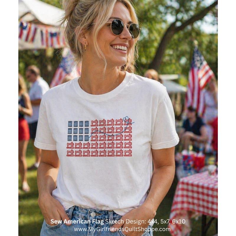 Woman wearing a white t-shirt with a flag design at an outdoor event.
