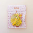 A yellow measuring tape roll with a small floral pattern, packaged in a white and pink strawberry-themed zip pouch. The brand name 'sewingillustration.